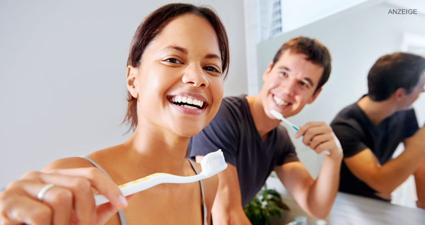 Glückliche Frau und glücklicher Mann beim Zähneputzen