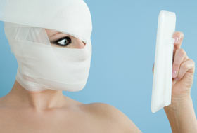 Frau mit Bandagen im Gesicht