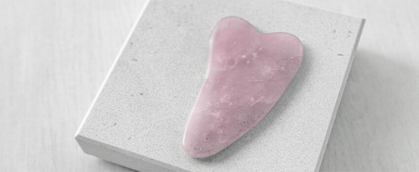 Gua Sha Schaber auf grauem Grund