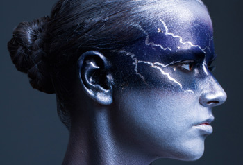 Frau mit grau-blauen Blitzen im Gesicht 