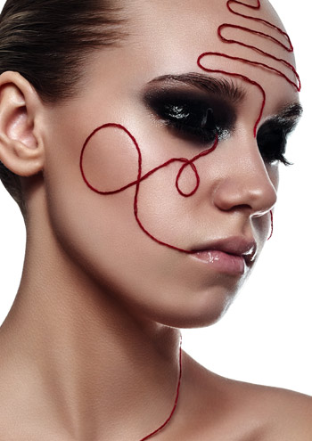 Profil einer Frau mit rotem Faden im Gesicht