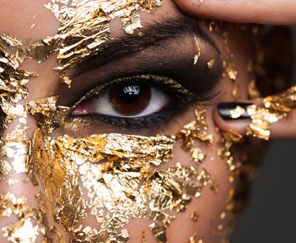 Frau mit Goldpartikeln im Gesicht