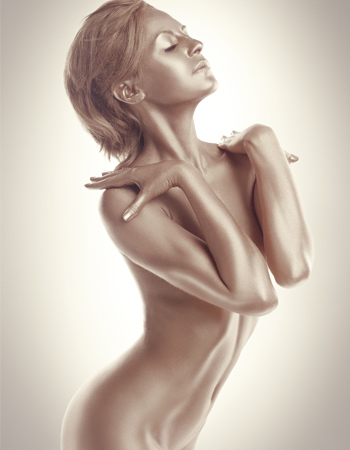 Frau mit nacktem Oberkörper und Goldschimmer auf der Haut