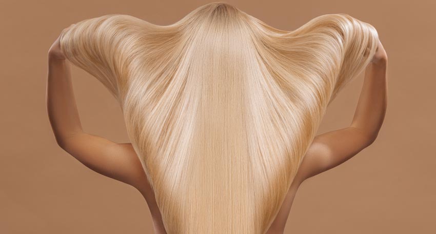 Rückenansicht einer Frau mit sehr langen blonden Haaren