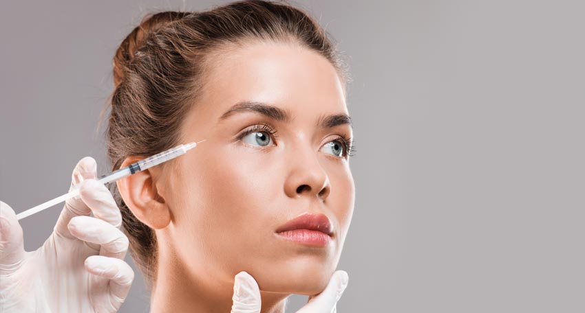 Frau bekommt eine Botox-Injektion in ihre Stirn
