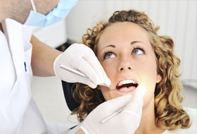 Frau beim Zahnarzt auf Behandlungsstuhl